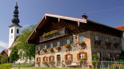 Ein Schlackestein gebautes Bauernhaus in Ainring mit Blumenschmuck