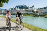 Radfahrer am Ufer der Salzach in der Salzburger Altstadt