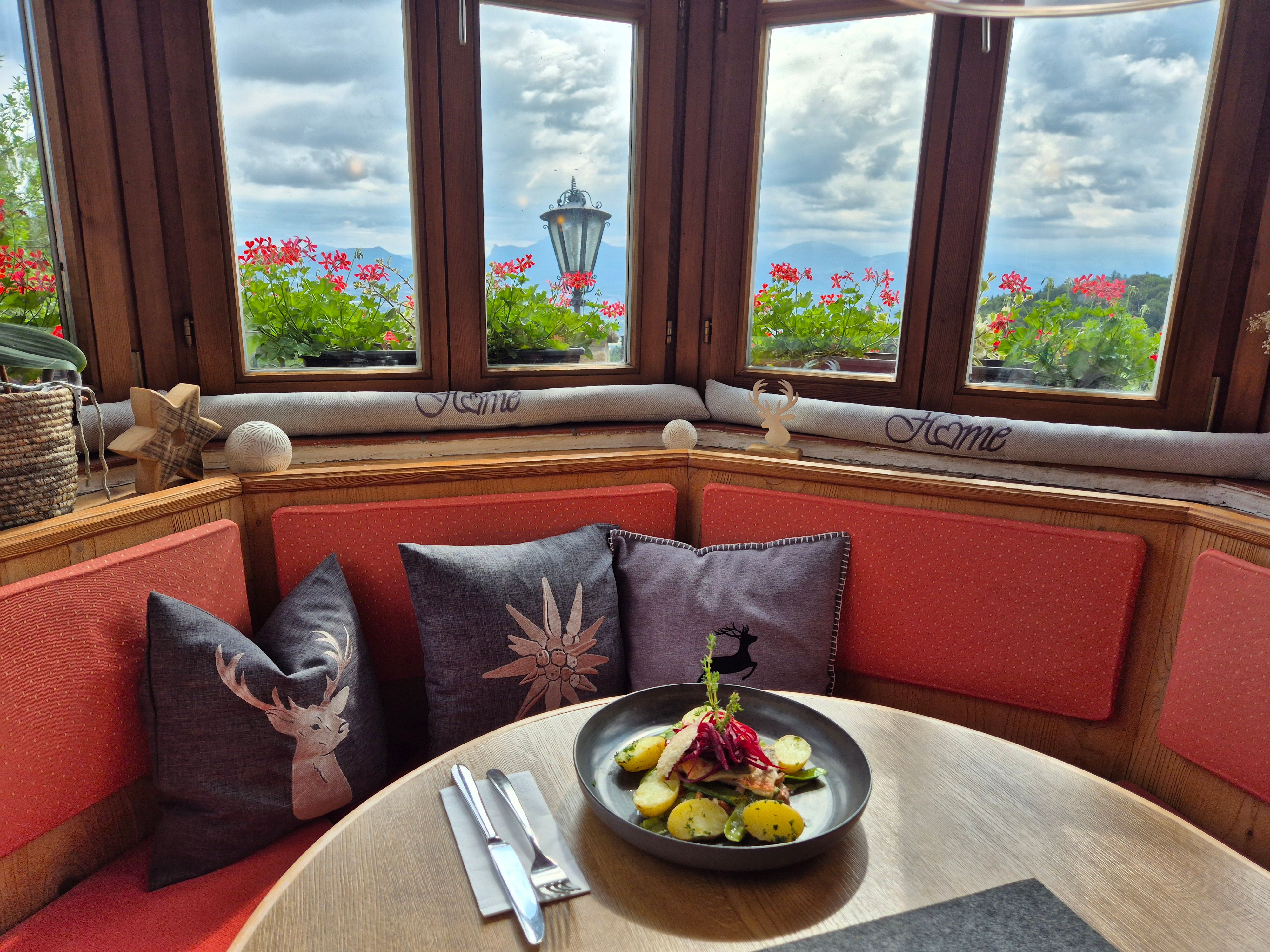angerichteter Teller im Restaurant der Neubichler Alm und wunderschönem Ausblick