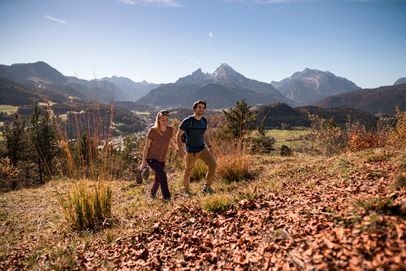 Ein Pärchen wandert im Herbst, im Hintergrund der Watzmann