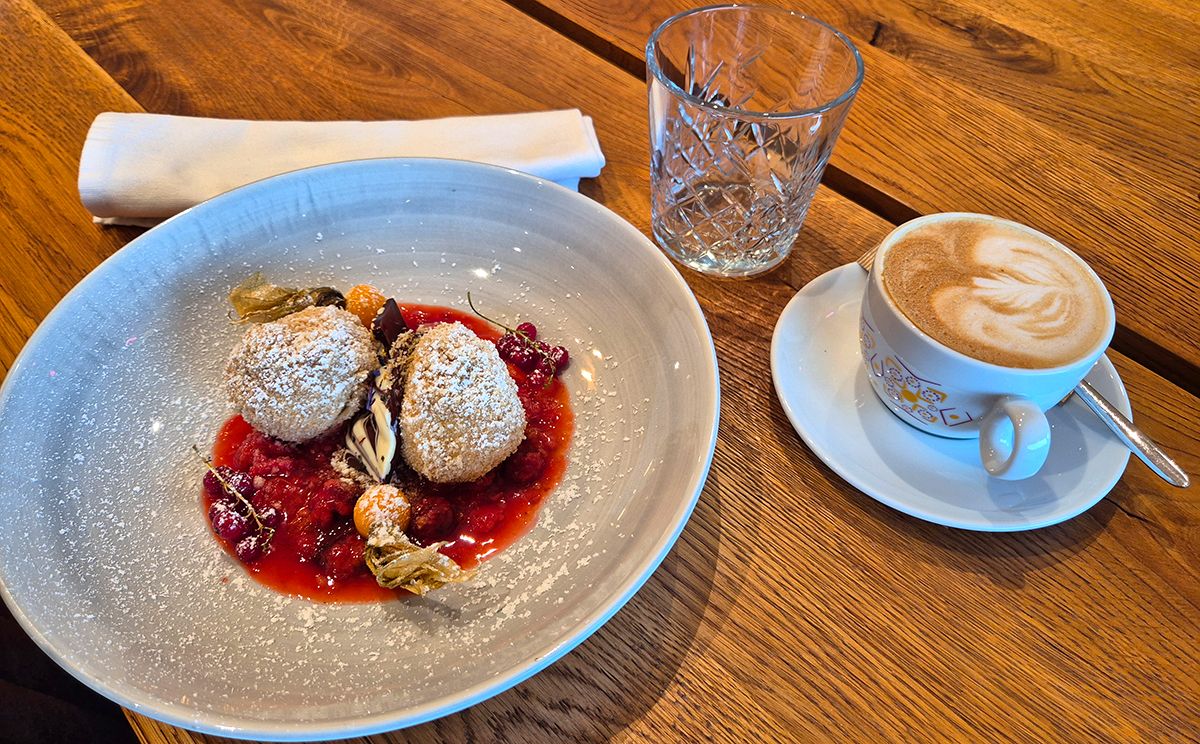 Topfenknödel mit Aprikosenfüllung auf einem Fruchtspiegel