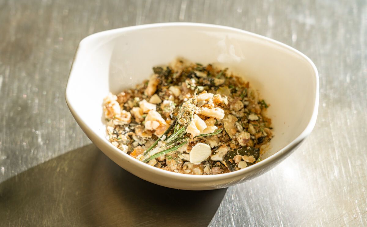 Karamellisierte Kürbiskerne und Walnüsse zerkleinern