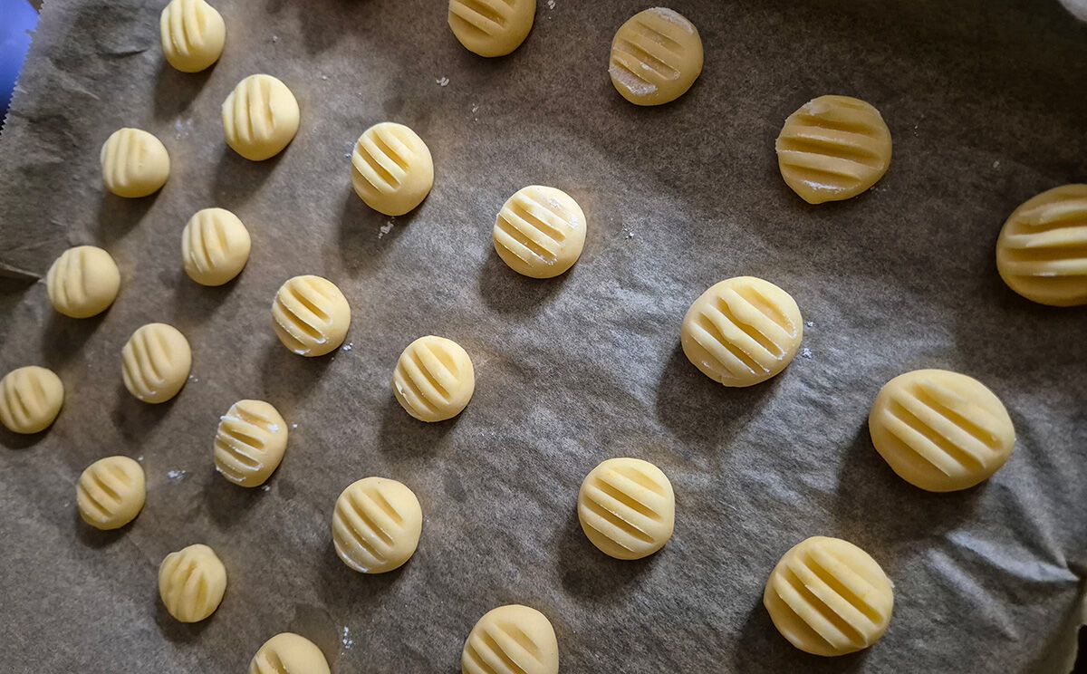 Aus dem Teig geformte Puddingplätzchen mit der Gabel andrücken