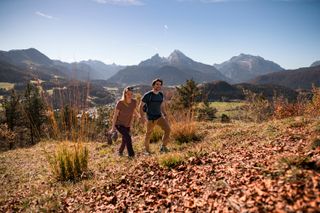 Ein Pärchen wandert im Herbst, im Hintergrund der Watzmann