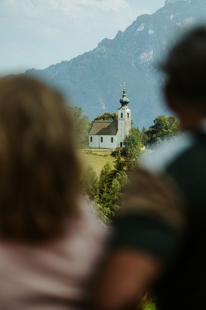 Blick über zwei unscharfe Silhouetten zur Kirche auf dem Johannishögl