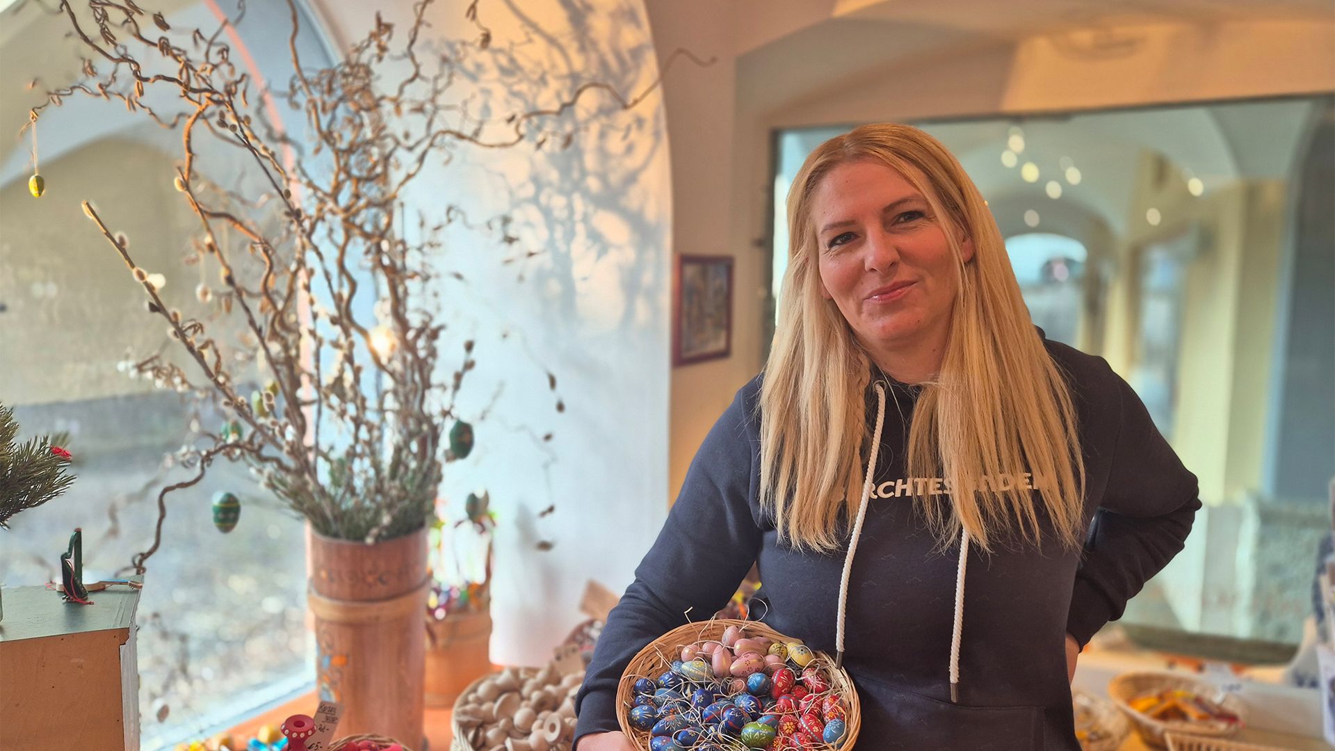 Astrid von der Handwerkskunst hält im Laden einen Korb fertig verzierter Ostereier