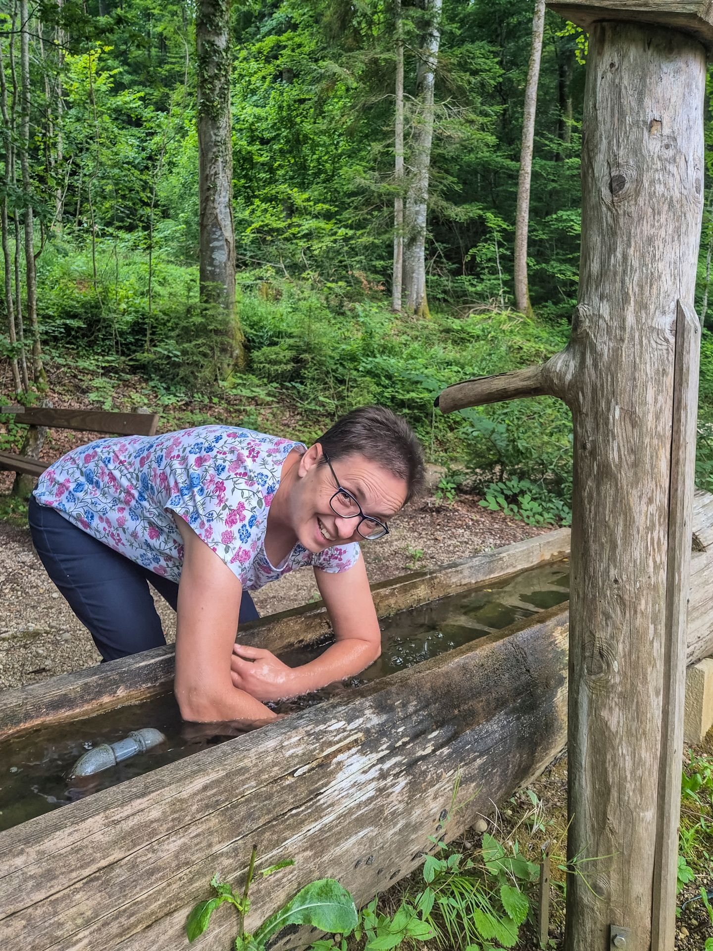 Barbara Spindler taucht ihre Arme für den Kreislauf in den Brunnen der Kneippanlage