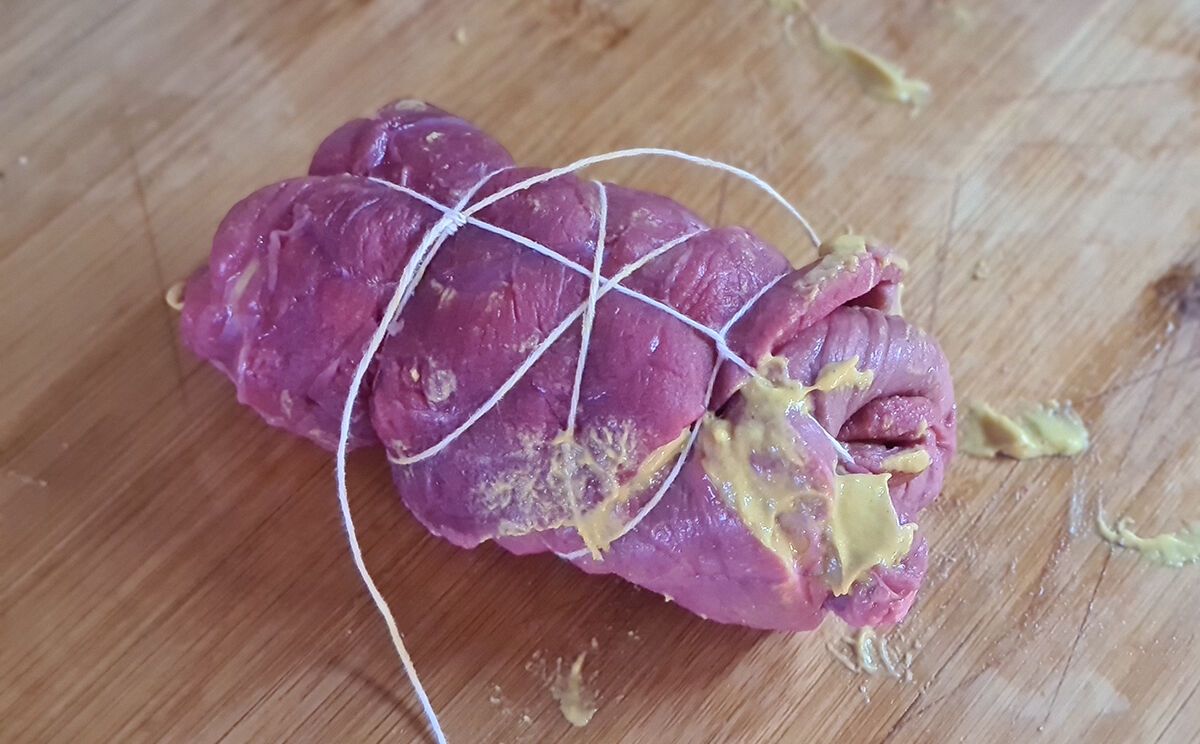 Fleisch seitlich einschlagen, einrollen und mit einem Zahnstocher oder Küchengarn fixieren