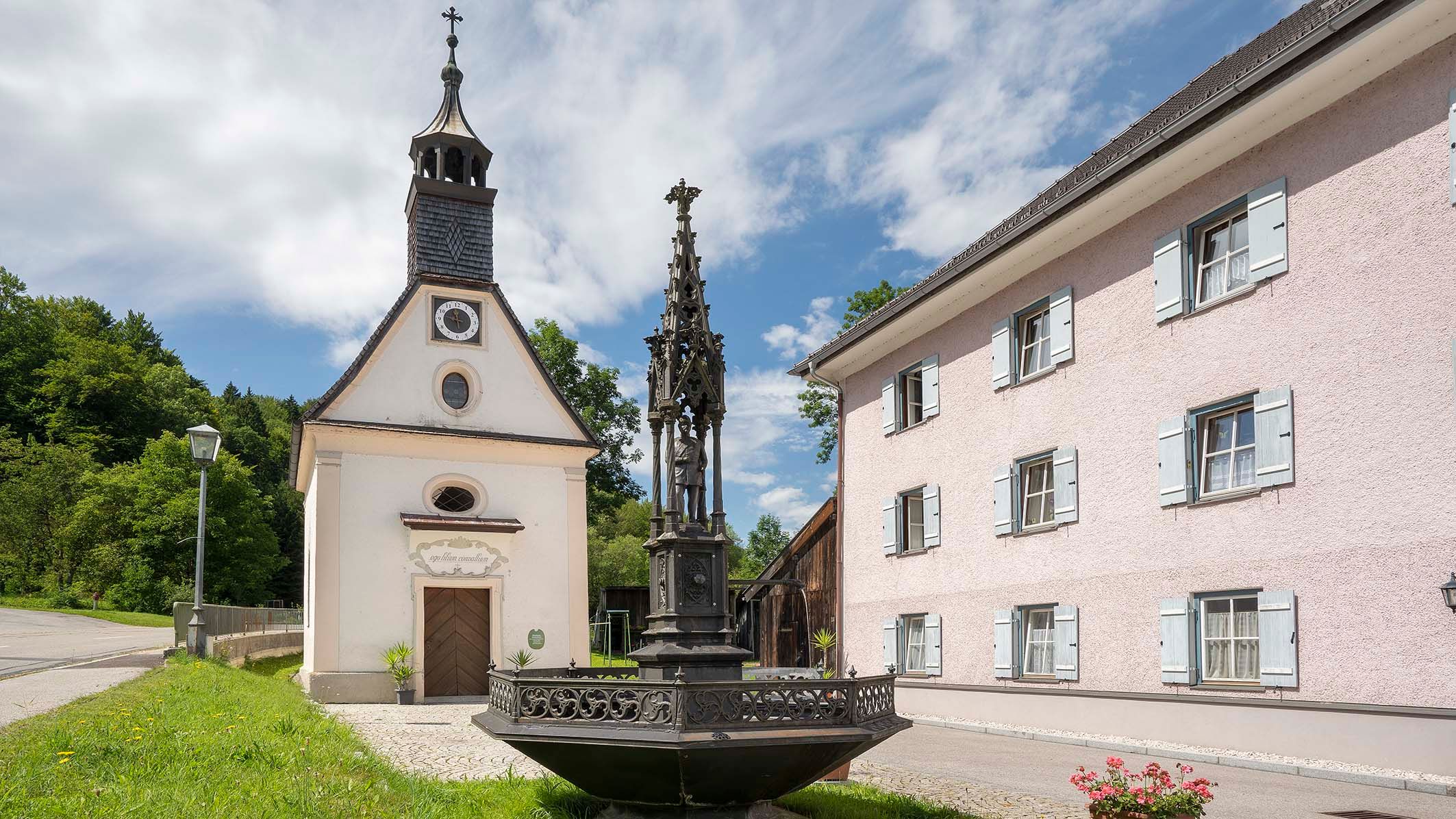 Brunnen und Kapelle an einem Wohnhaus in Teisendorf