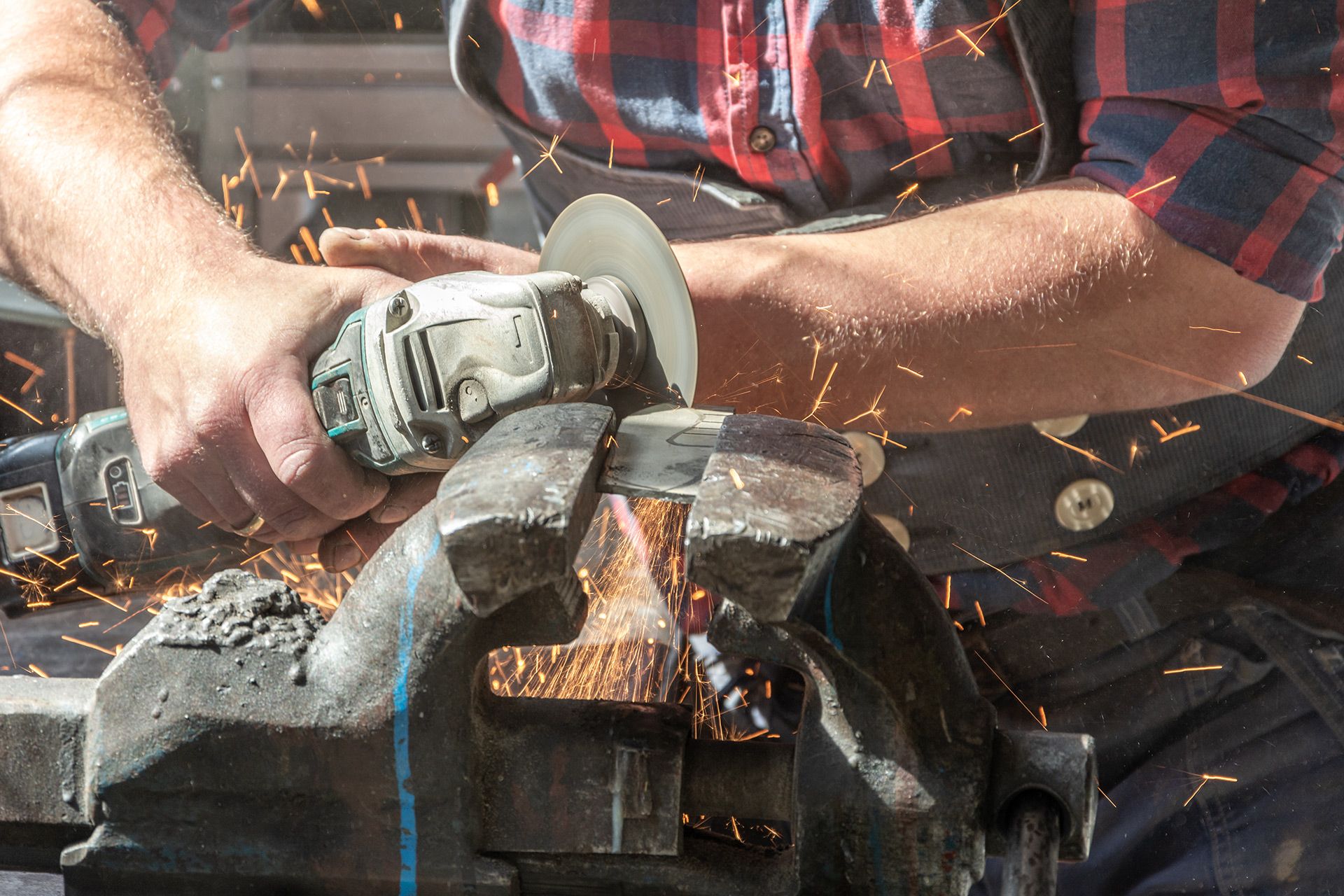 Der Messer Sepp in der Werkstatt mit einer Flex